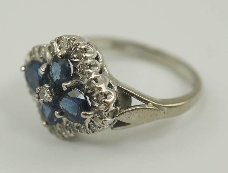 A modern 18ct white gold, sapphire and diamond cluster set ring